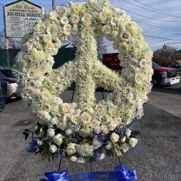 Large white floral peace sign display with blue ribbon bows