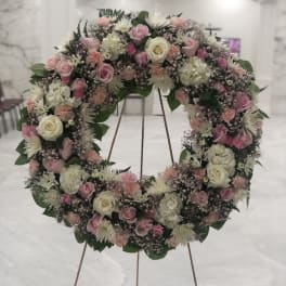 Large floral wreath of pink and white roses on a stand
