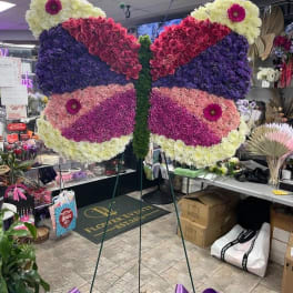 Butterfly-shaped floral display on a stand with purple and pink flowers