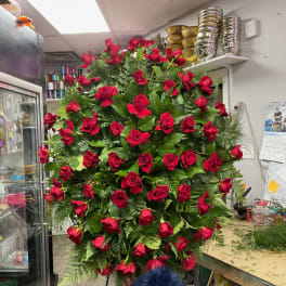 Large standing arrangement of red roses with greenery