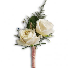 White rose boutonniere with greenery and pink ribbon wrap