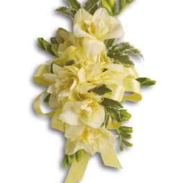 Yellow floral corsage with ribbon and green accents