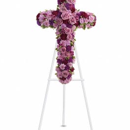 Purple and pink floral cross on a white stand