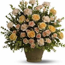 Cream roses and white carnations in a textured urn vase