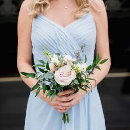 Woman holding a pale pink and white bridal bouquet