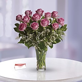 Pink roses arranged in a clear glass vase with white filler flowers