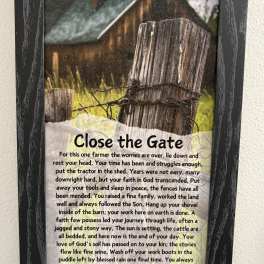 Framed memorial sign with a farm gate and poem text
