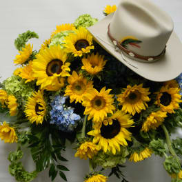Sunflower arrangement with a beige cowboy hat on top