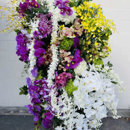 Large standing arrangement of purple, white, and yellow orchids