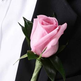 Pink rose boutonniere on a black suit jacket