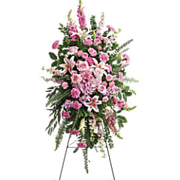 Tall pink and white funeral spray on a stand