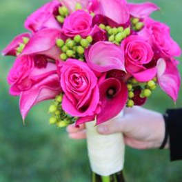 Handheld bouquet of hot pink roses and calla lilies