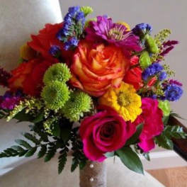 Colorful bouquet of roses and mixed flowers with a wrapped handle