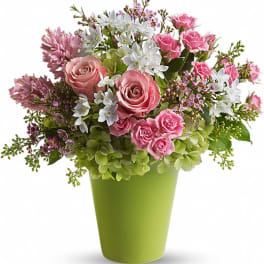 Pink and white mixed flower arrangement in a green vase