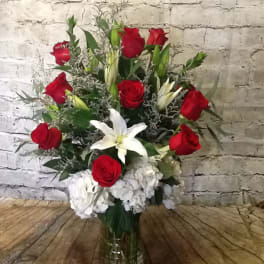 Red roses and white lilies in a clear glass vase
