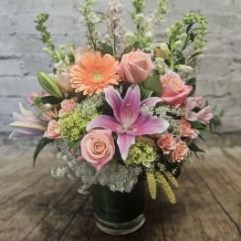 Mixed bouquet with pink lilies, roses, and peach gerbera daisies in a vase