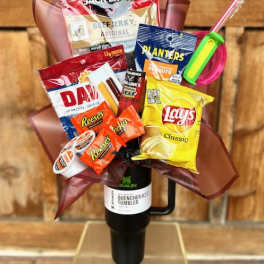 Snack bouquet in a black tumbler with chips, candy, jerky, and peanuts