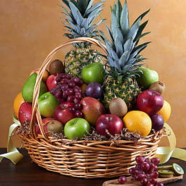 Fruit basket with pineapples, apples, grapes, oranges, and kiwis
