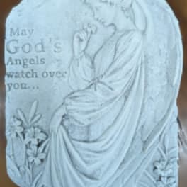 White memorial plaque with an angel and flowers