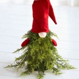 Red velvet gnome figure with a long green mossy skirt