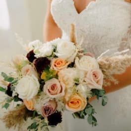 Bride holding a bouquet of white and peach roses