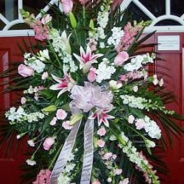 Large pink and white funeral spray with lilies and ribbon