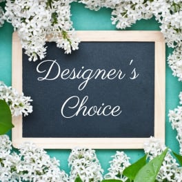 Framed sign reading Designer's Choice surrounded by white flowers