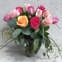 Bouquet of multicolored roses in a clear glass vase