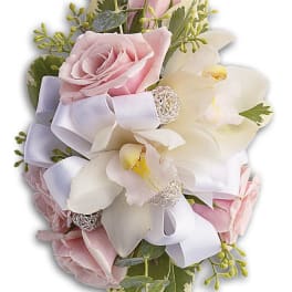 Pink roses and white orchids arranged with a lavender ribbon