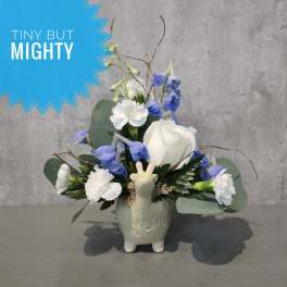 Small blue and white floral arrangement in a ceramic vase