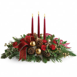 Christmas centerpiece with red candles, pinecones, and red ribbon