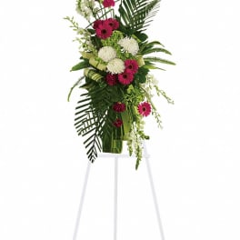 Tall floral spray with pink and white flowers on a white easel