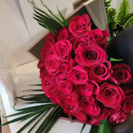 Bouquet of hot pink roses with palm leaves
