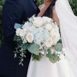 Bride holding a white rose bouquet with eucalyptus