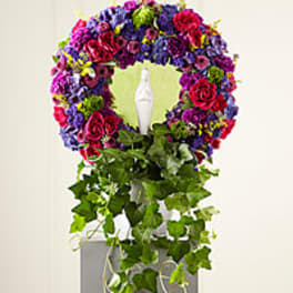 Colorful floral wreath with a white statue in the center and trailing ivy