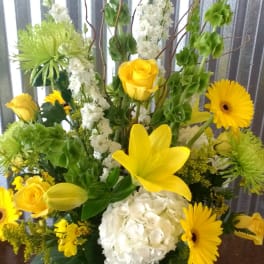 Yellow and white floral arrangement in a clear glass vase