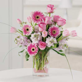 Pink roses and gerbera daisies in a clear glass vase