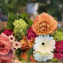 Mixed bouquet with peach roses, white daisies, and bright pink blooms