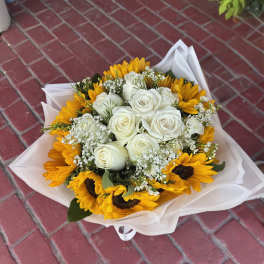 Bouquet of white roses and yellow sunflowers wrapped in white paper