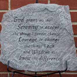 Engraved gray stone plaque with a quote on a brick wall
