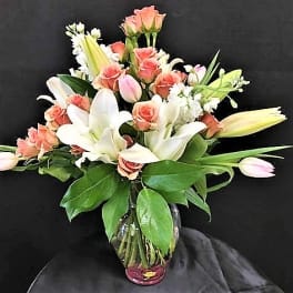 Bouquet of pink roses and white lilies in a glass vase