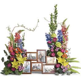 Floral photo frame display with colorful flowers around several framed photos