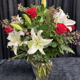 Bouquet of red roses and white lilies in a clear glass vase