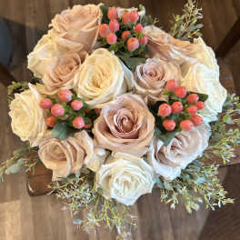 Bouquet of blush and white roses with pink berry accents