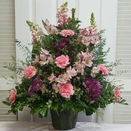 Large mixed flower arrangement in a dark green container