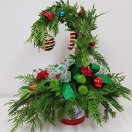Christmas tree-shaped evergreen arrangement with ornaments and ribbon