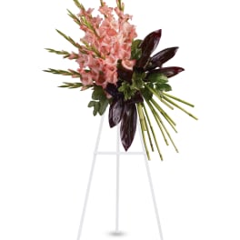 Pink gladiolus arrangement with dark leaves on a white stand