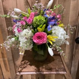 Colorful mixed bouquet in a vase with pink roses and white lilies