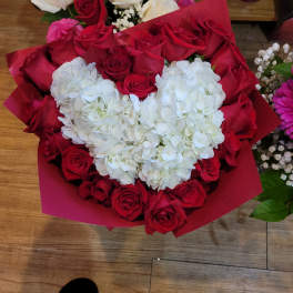Heart-shaped bouquet of red roses with white hydrangeas