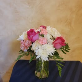 Pink roses and white chrysanthemums arranged in a glass vase